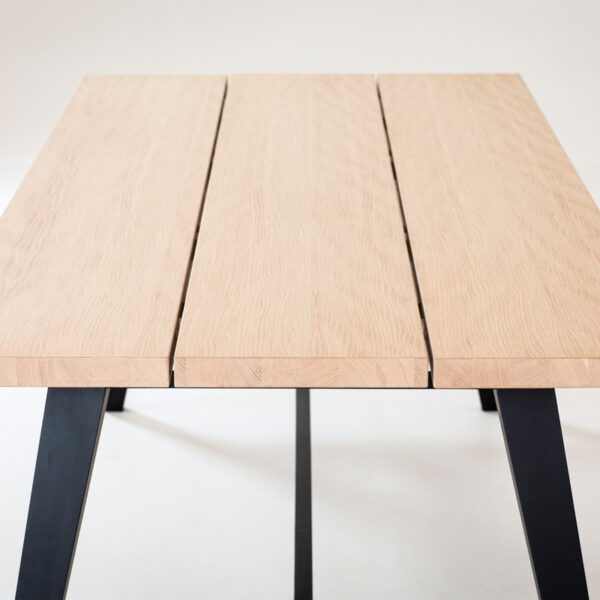 Bedrock matbord från Torkelson. Detta matbord har en skiva i vitoljad ek med ben / underrede i svartbetsat trä. Skivan är uppdelad i tre plankor.
